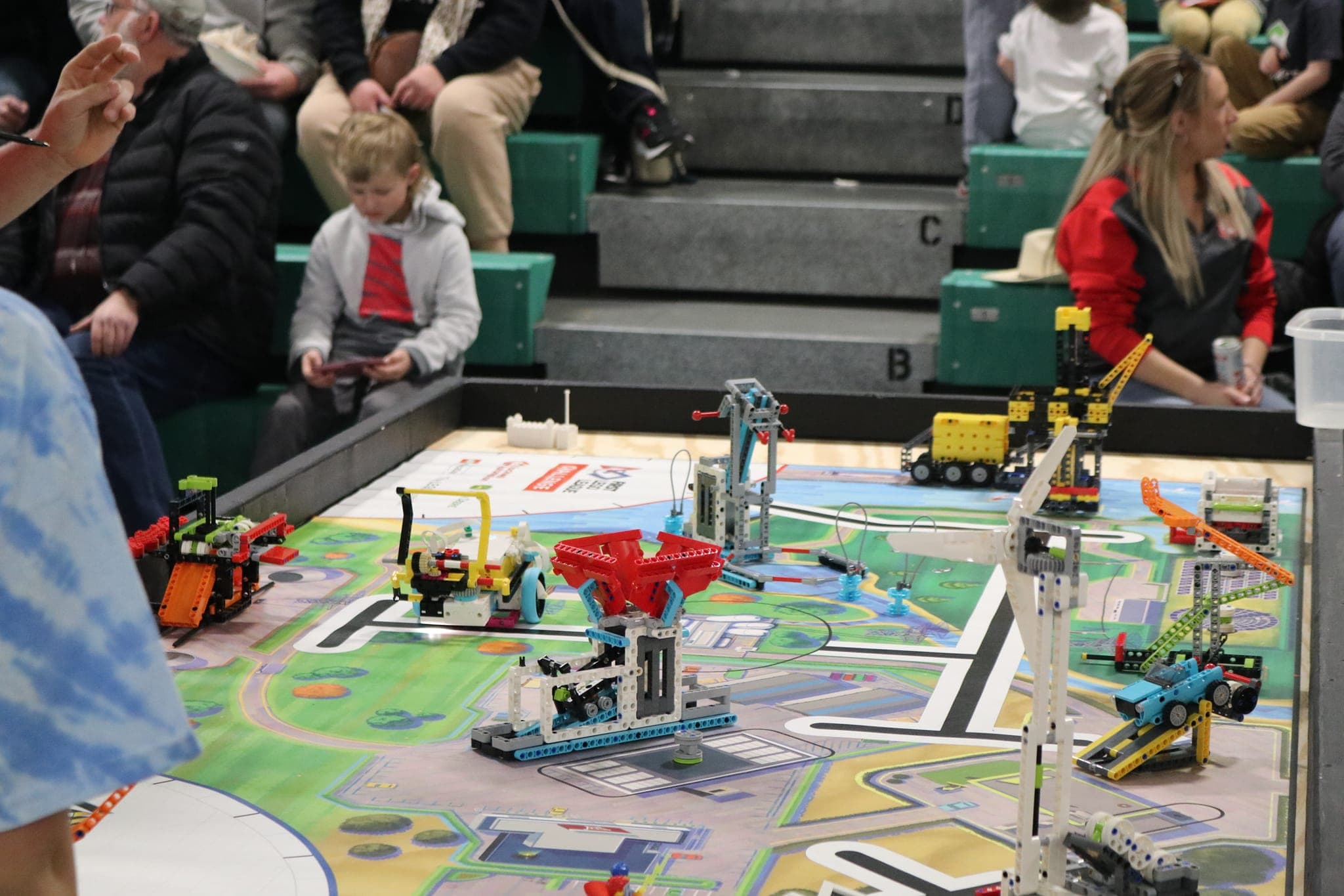 Young FLL builders working their robot on the challenge mat.